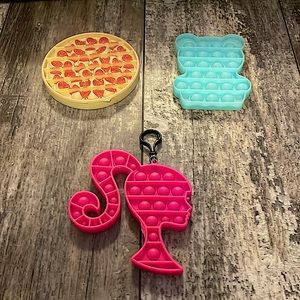 Pizza pop it, Barbie keychain pop it, and sparkly gummy bear pop it